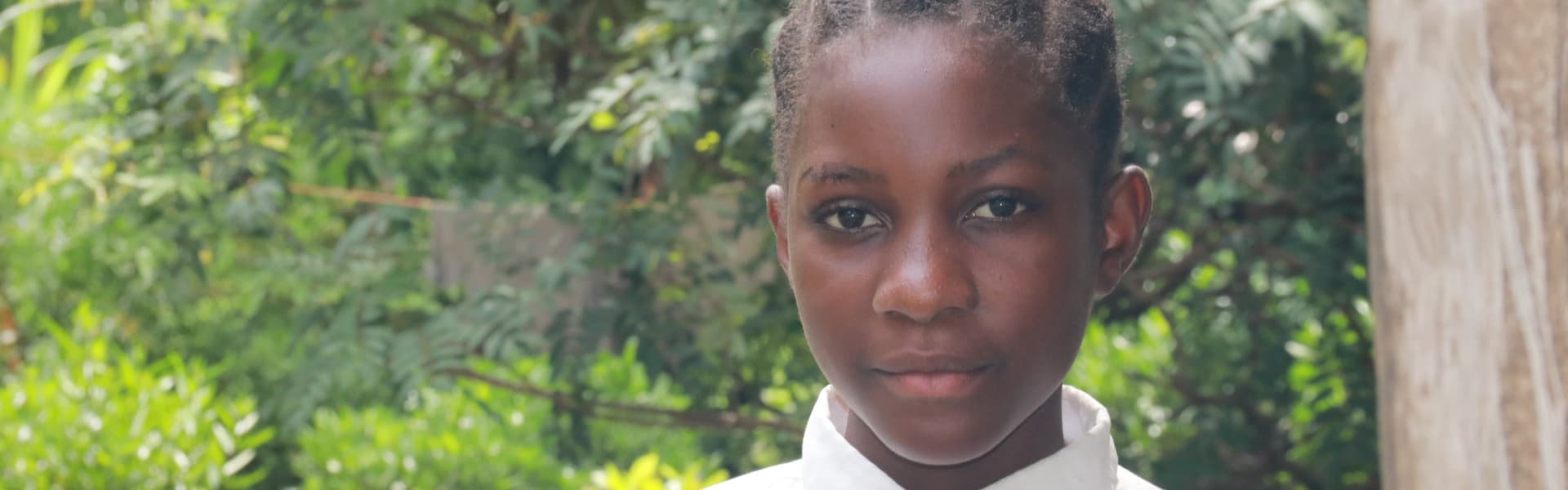 a child outdoors near trees and bushes