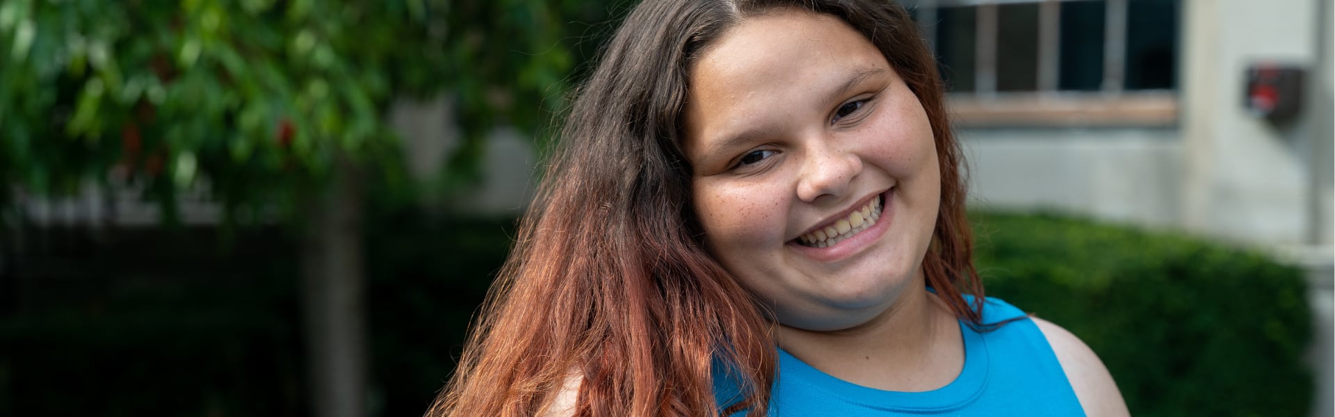 A young girl smiling outdoors