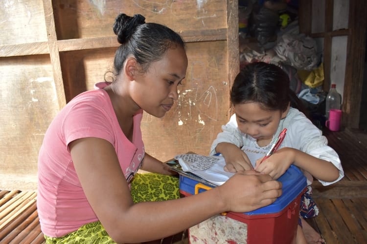 A mother and daughter writing on a piece of paper
