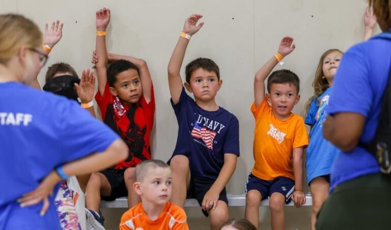 A group of children raising their hands